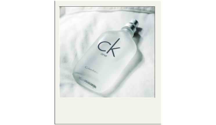 mujer aplicándose rico perfume
